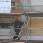 Der Bauherr steigt auf das Dach, um den letzten Nagel einzuschlagen. Der Bauherr steigt auf das Dach, um den letzten Nagel einzuschlagen.